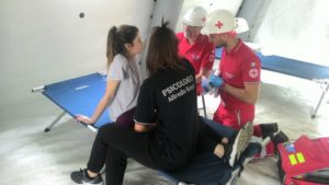 Psicologa e vittima con operatori CRI all'interno di un PMA