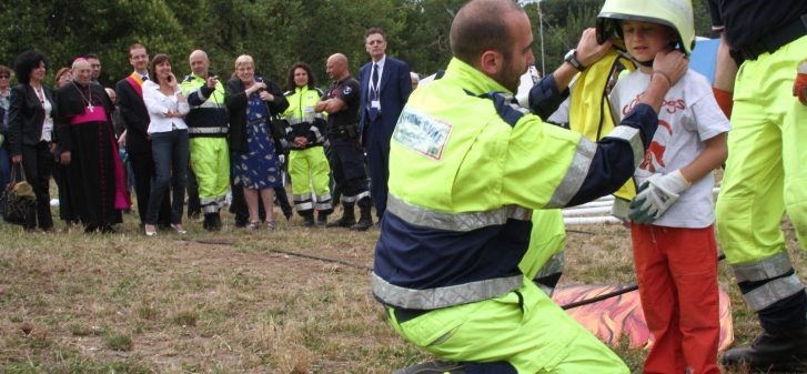 Un soccorritore mette un elmetto sulla testa di un bambino